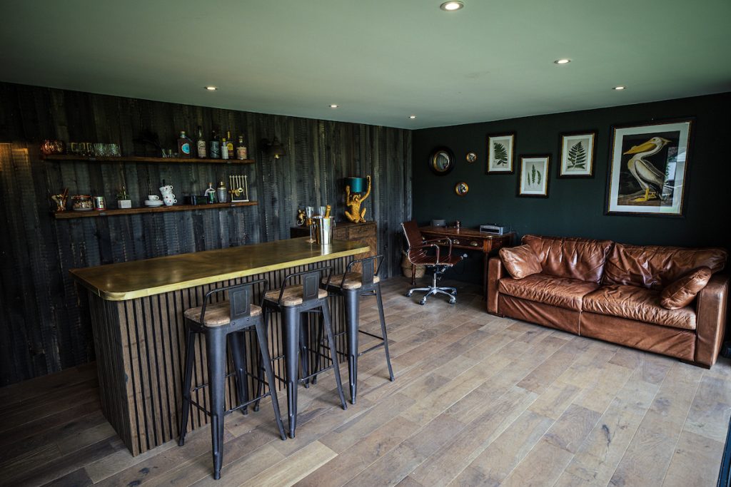 Inside view of a garden room containing a bar and leather couch