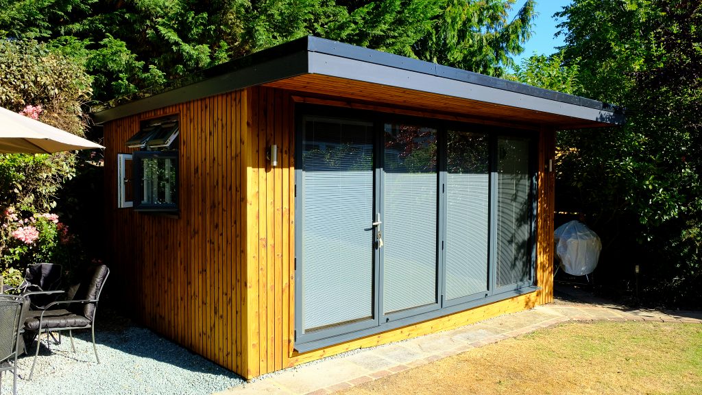 Small wooden building in the garden with glass doors