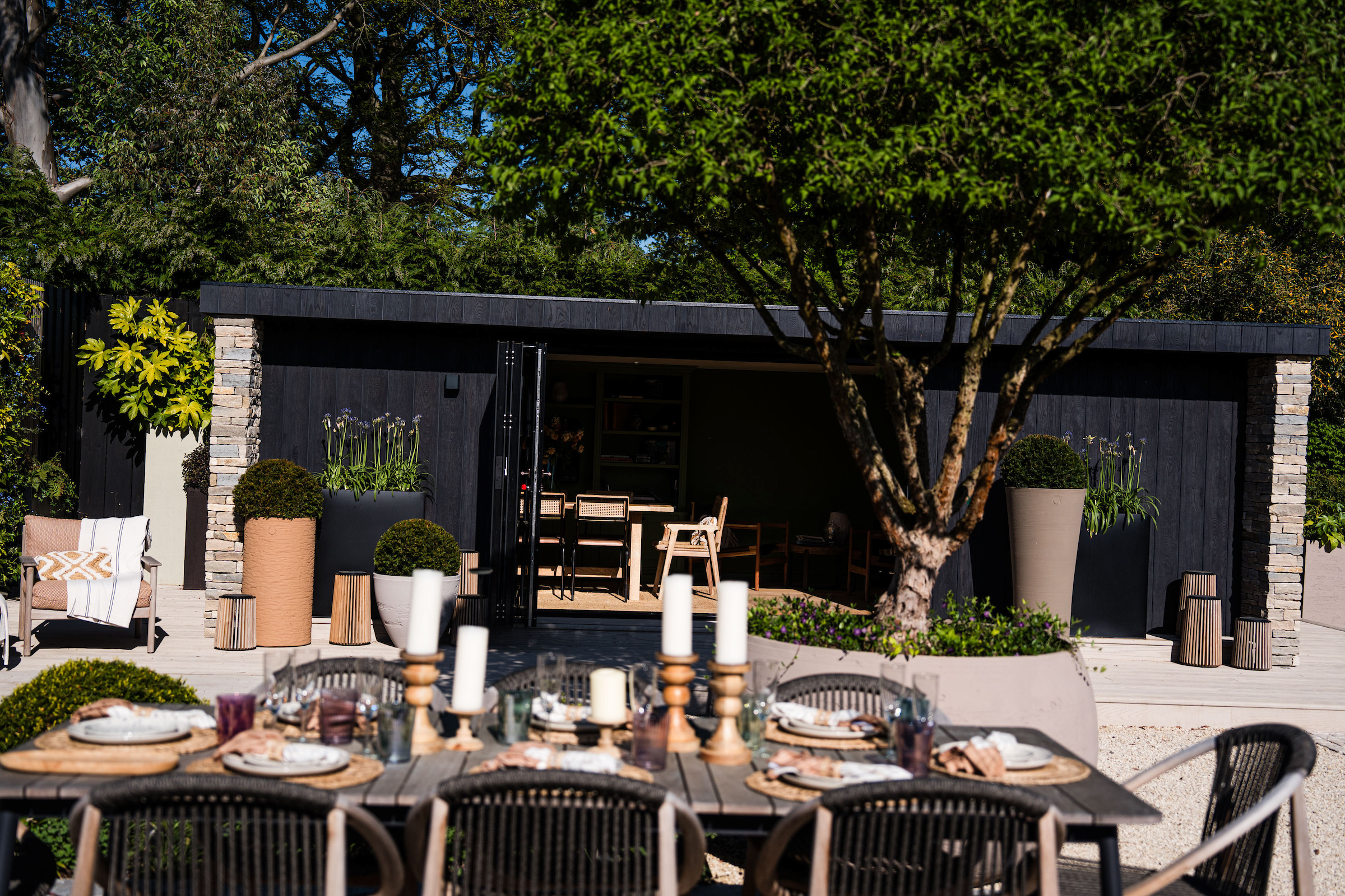 Outdoor dining terrace at dusk by Into The Garden Room